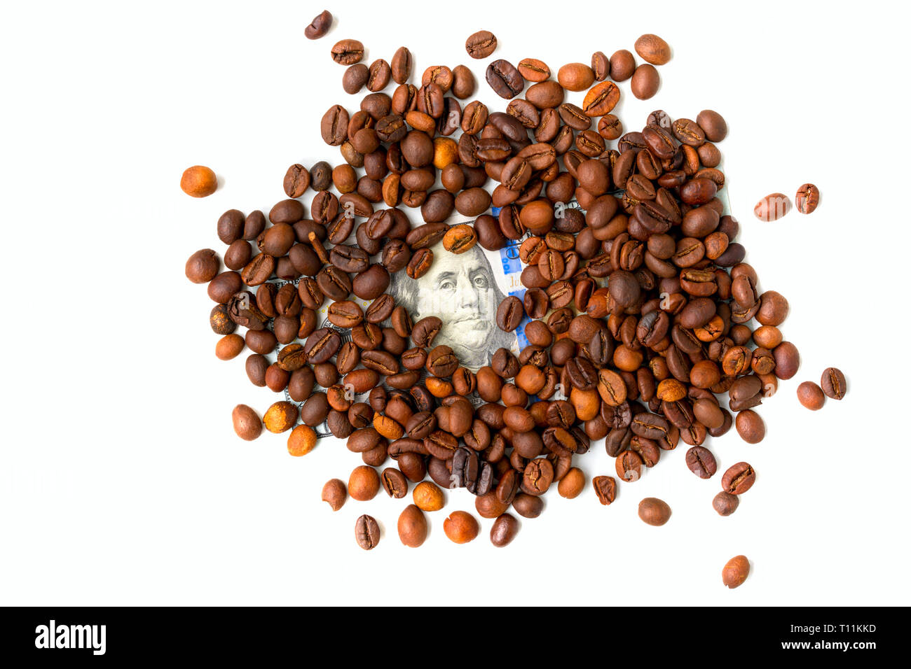 Les grains de café et une centaine de dollars. Les grains de café torréfié. Concept financier. Isolated on white Banque D'Images