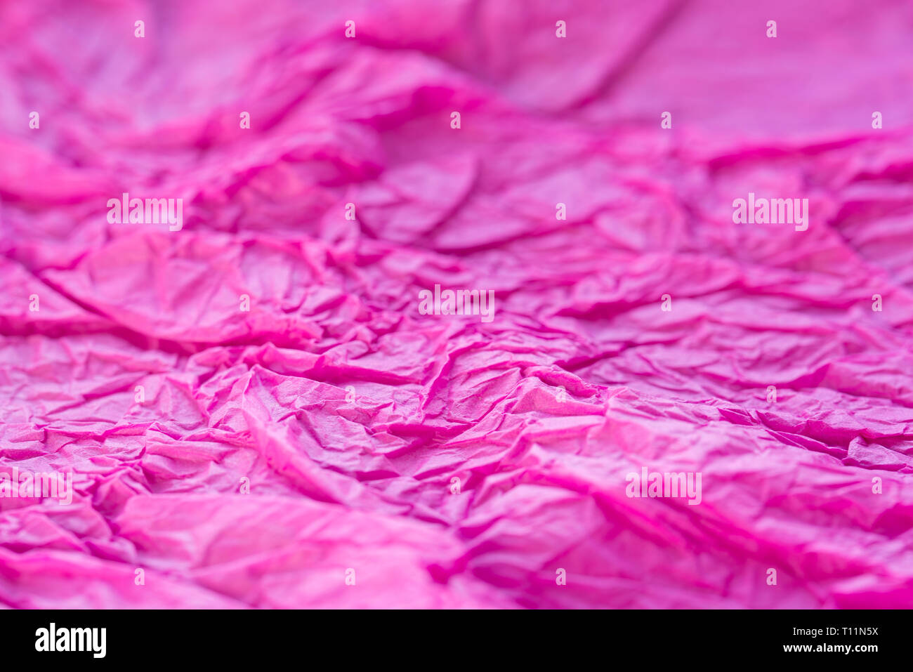 Couleur rose tissu froissé papet sélective focus macro texture de fond Banque D'Images