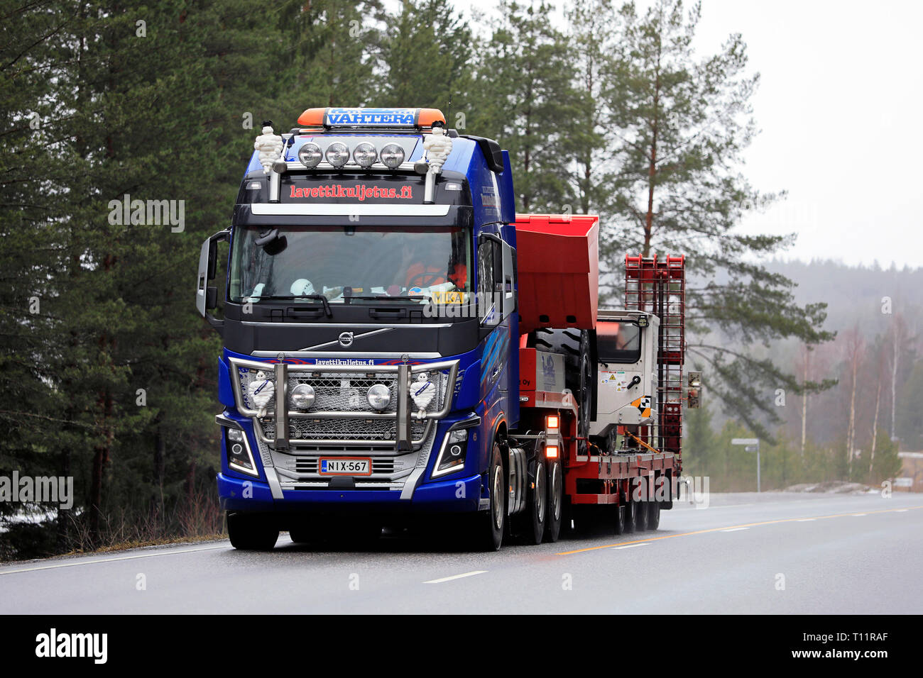 Salo, Finlande - le 15 mars 2019 : Volvo FH16 750 semi-remorque d'Lavettikuljetus Ylitalo & Vahtera Oy parcours Sandvik LH209 chargeuse L sur route. Banque D'Images