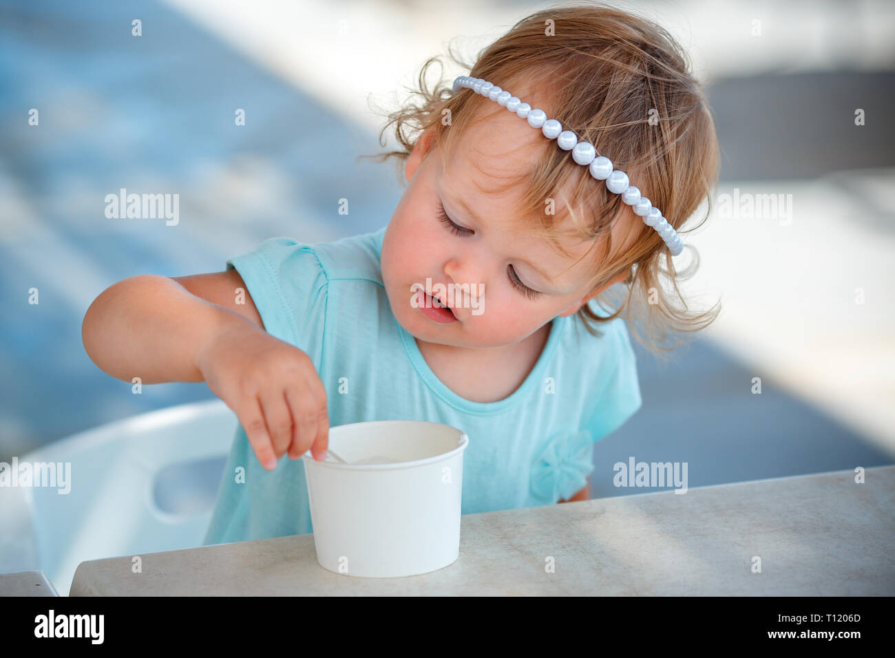 Adorable little girl eating ice cream au café en plein air sur la belle journée d'été Banque D'Images