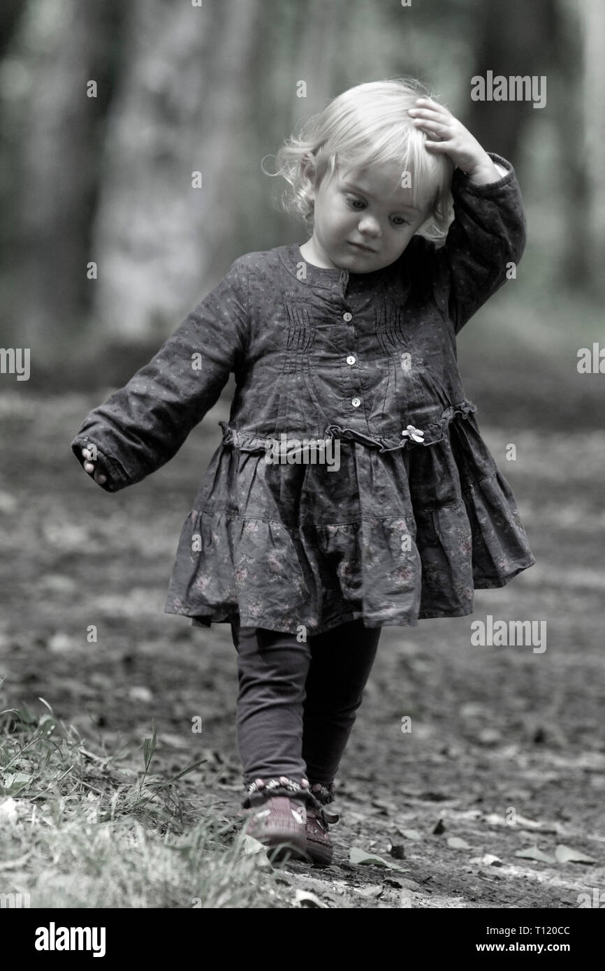 Deux ans girl walking in woodland holding head. M. disponible. Banque D'Images