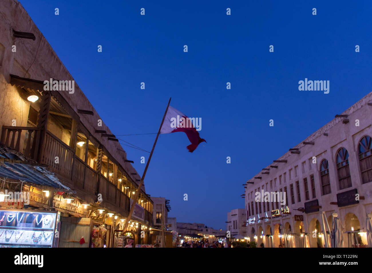 Souq Waqif de nuit avec un drapeau du Qatar à Doha, au Qatar, au Moyen-Orient. Banque D'Images