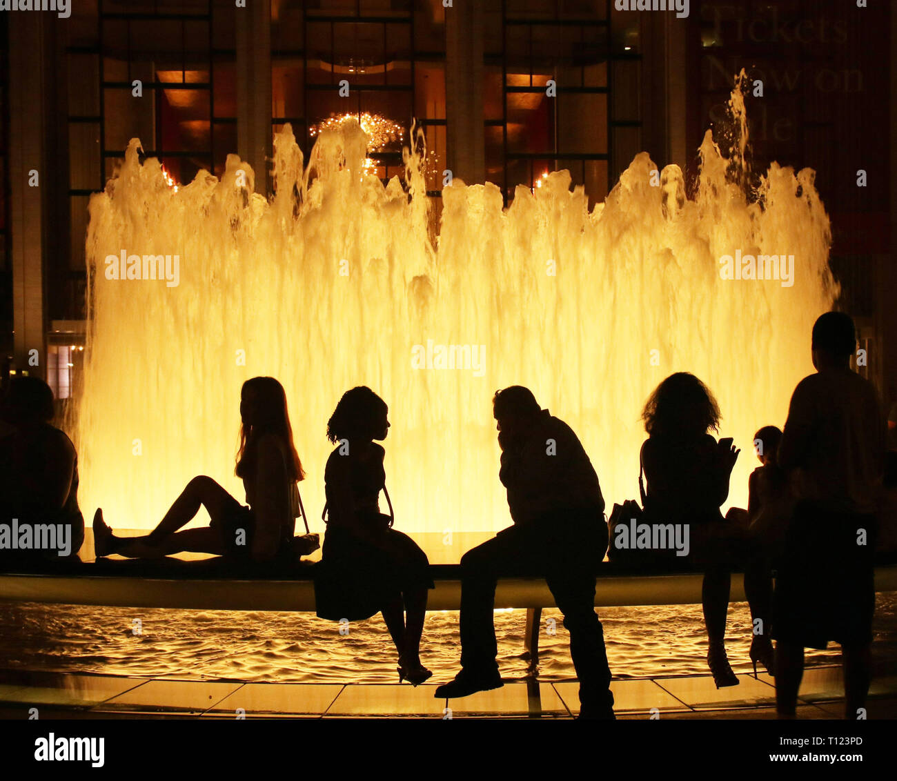Les gens assis à la fontaine au Lincoln Center, New York, la nuit Banque D'Images