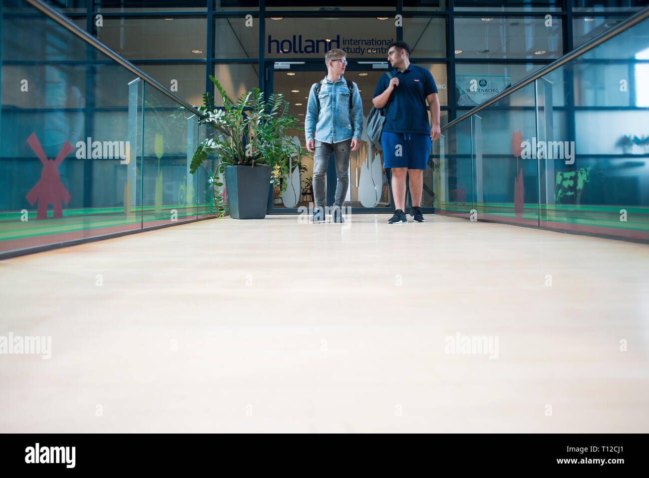 Les étudiants étrangers de sexe masculin dans le couloir lumineux et modernes de leur collège. Banque D'Images