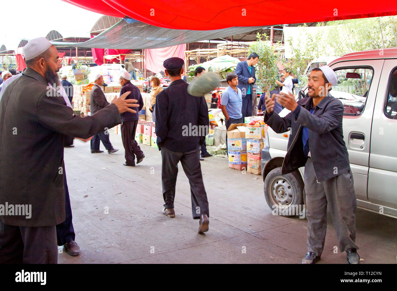 Des hommes d'Uyghur déchargent des pastèques sur le célèbre marché du dimanche de Kashgar, dans la région autonome du Xinjiang, en Chine. Banque D'Images