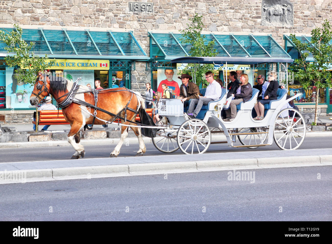 BANFF, CANADA - LE 3 JUILLET 2011 : les touristes sur un cheval calèche à travers l'avenue Banff, dans les Rocheuses canadiennes de l'Alberta. La ville est un important Banque D'Images