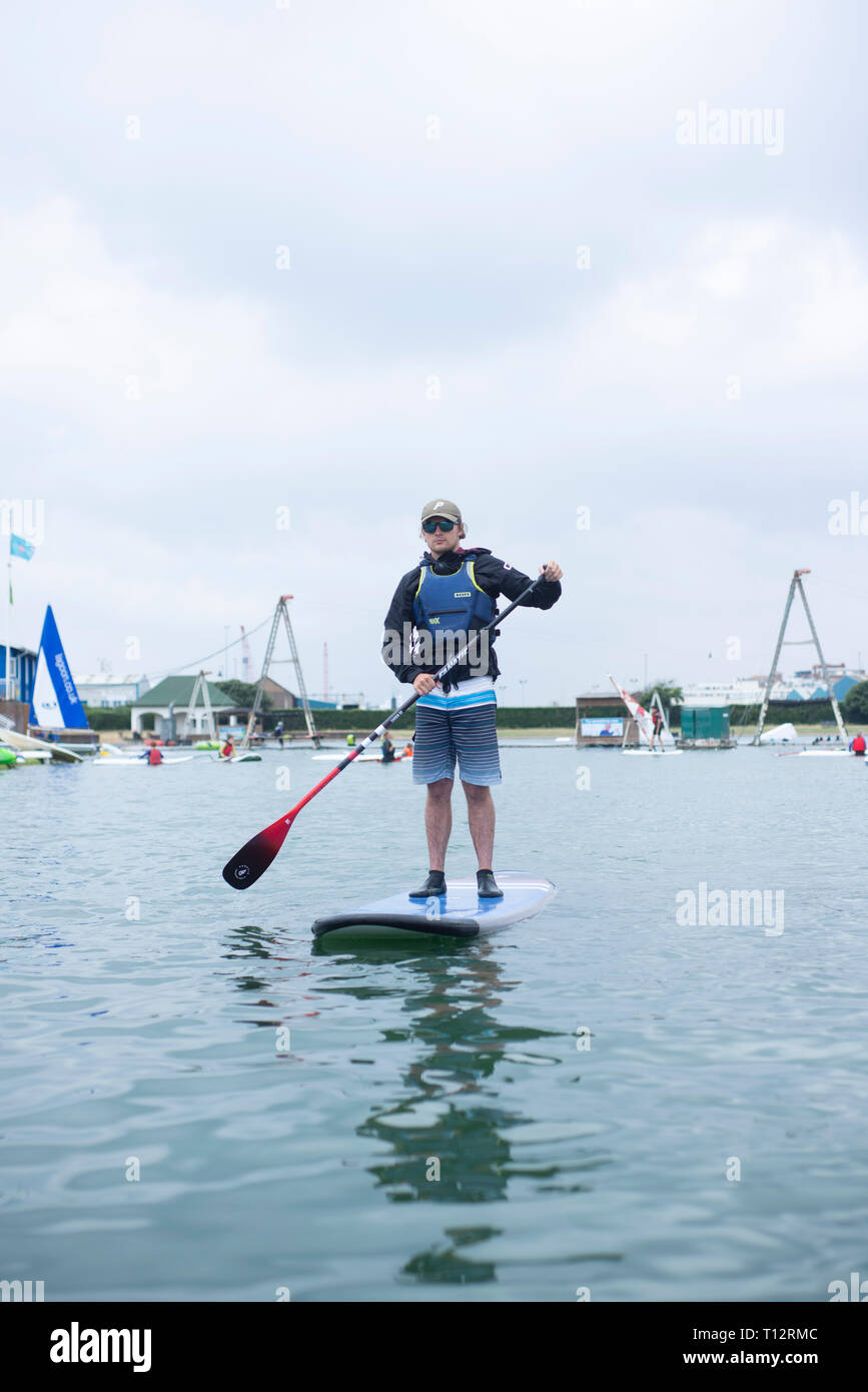 Un mâle en stand up paddle boarder à Hove Lagoon Banque D'Images