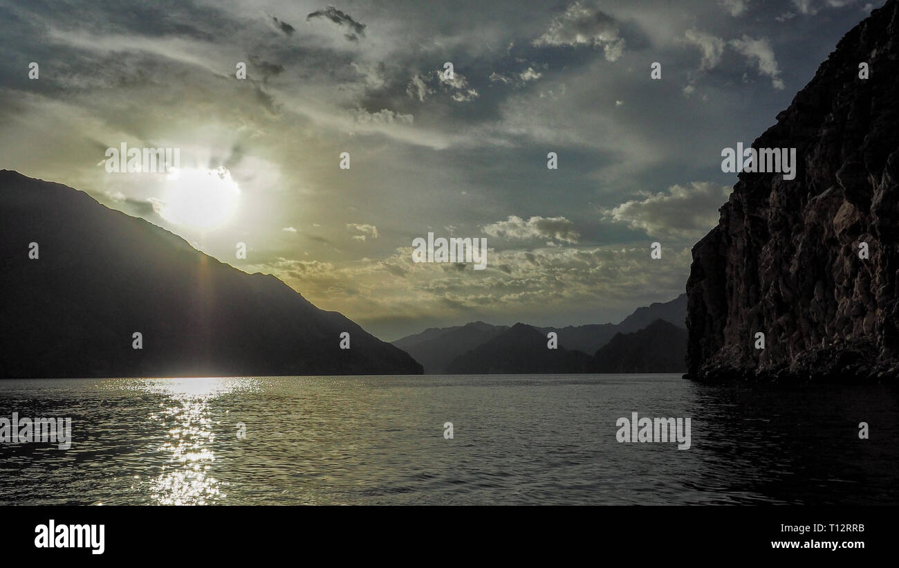 Soleil sur l'arrière-plan de montagnes et la mer. Les fjords de la péninsule de Musandam. Khasab bay. Oman Banque D'Images