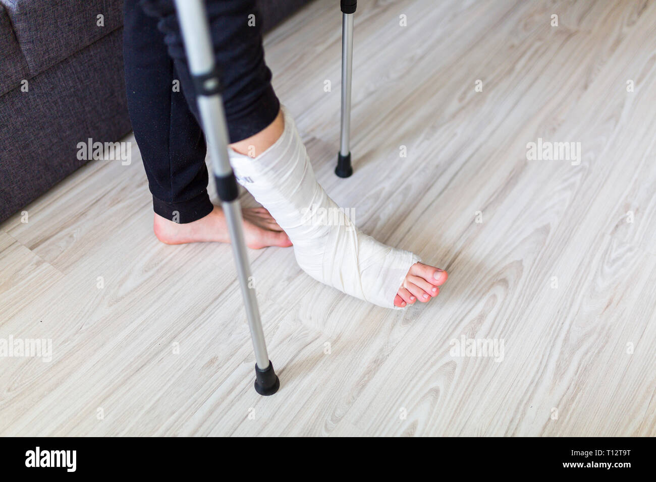 L'homme essaie de marcher avec une jambe cassée Banque D'Images