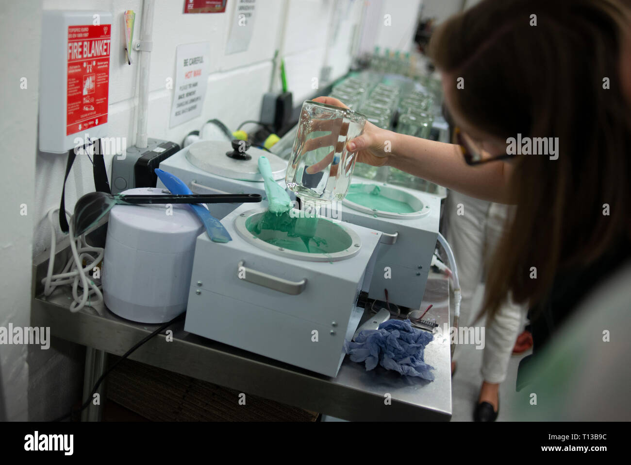 Trempant une bouteille de gin dans la cire chaude pour le fermer Banque D'Images