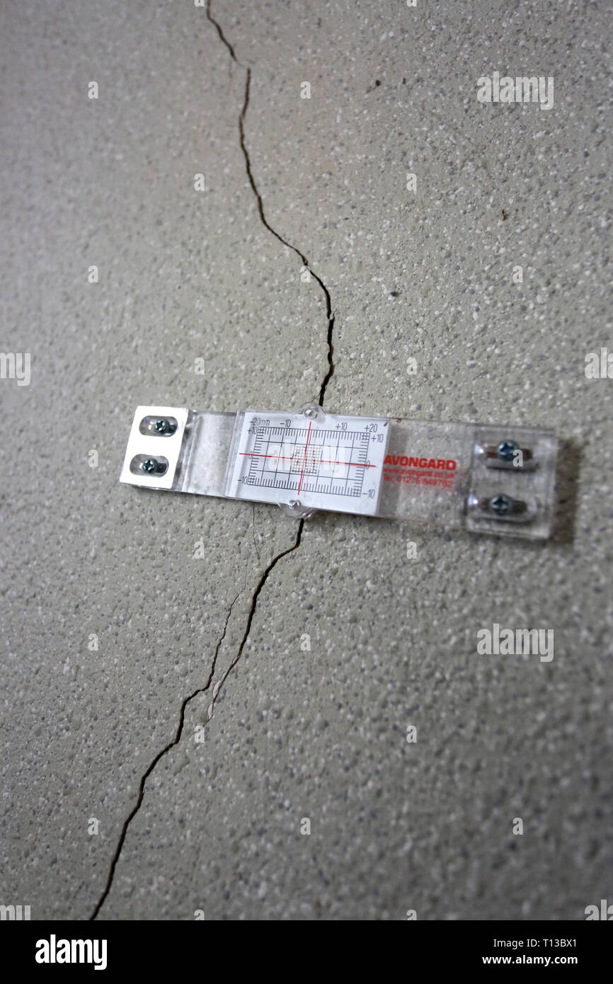Vue générale d'une machine pour le suivi et l'affaissement de la structure de l'édifice des capacités de surveillance du mouvement, représenté sur une fissure dans un mur. Londres, Royaume-Uni. Banque D'Images