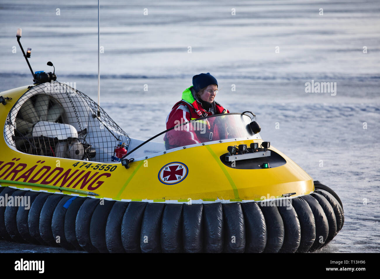 Membre de l'équipage féminin sur un aéroglisseur de la Société de sauvetage en mer sur la glace du lac Malaren, Sigtuna, Suède, Scandinavie Banque D'Images
