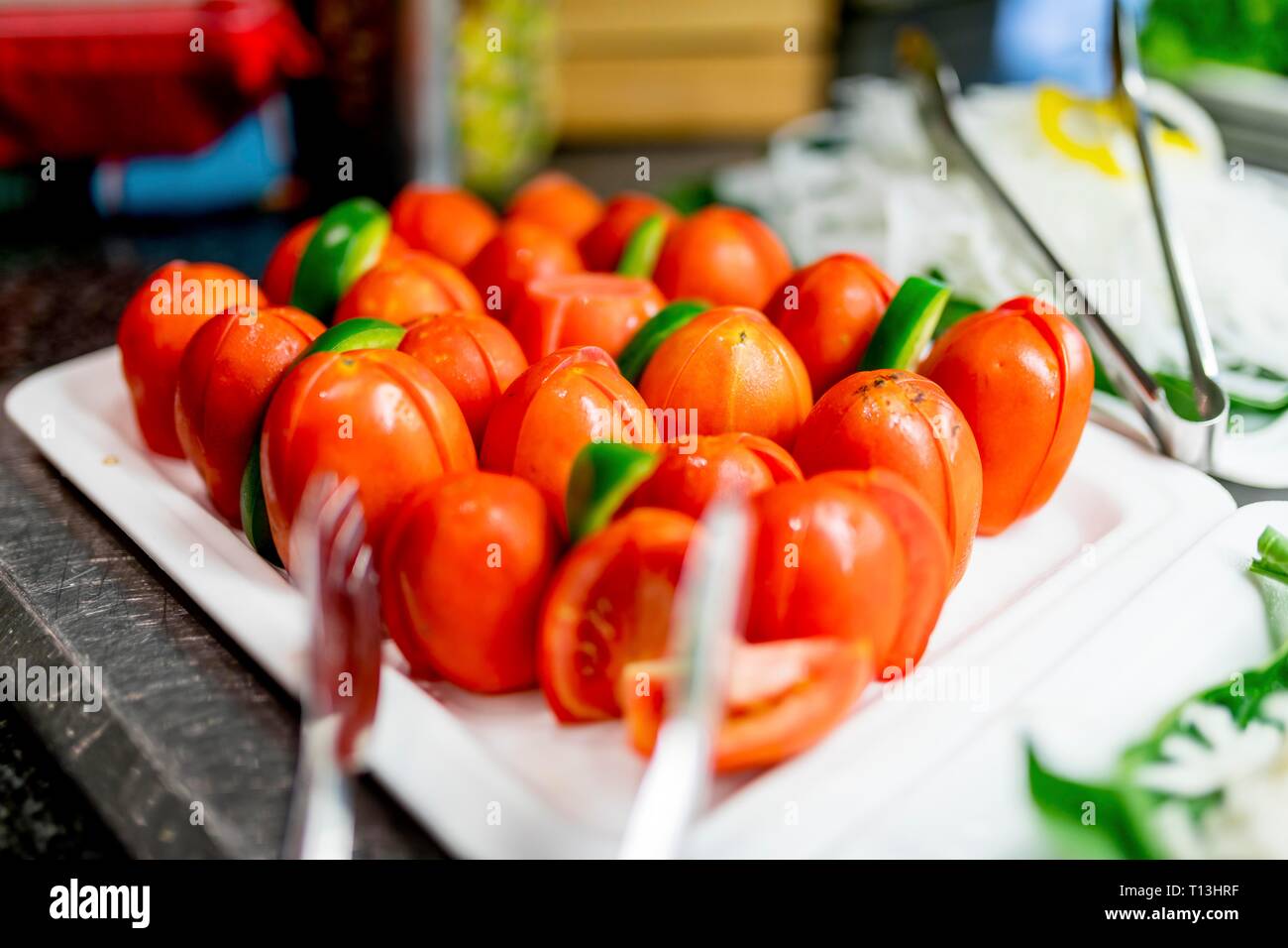 Close up of frais et délicieux couper les tomates cerise sur un bar-buffet servi comme une salade ou garnir de pinces de service. Banque D'Images