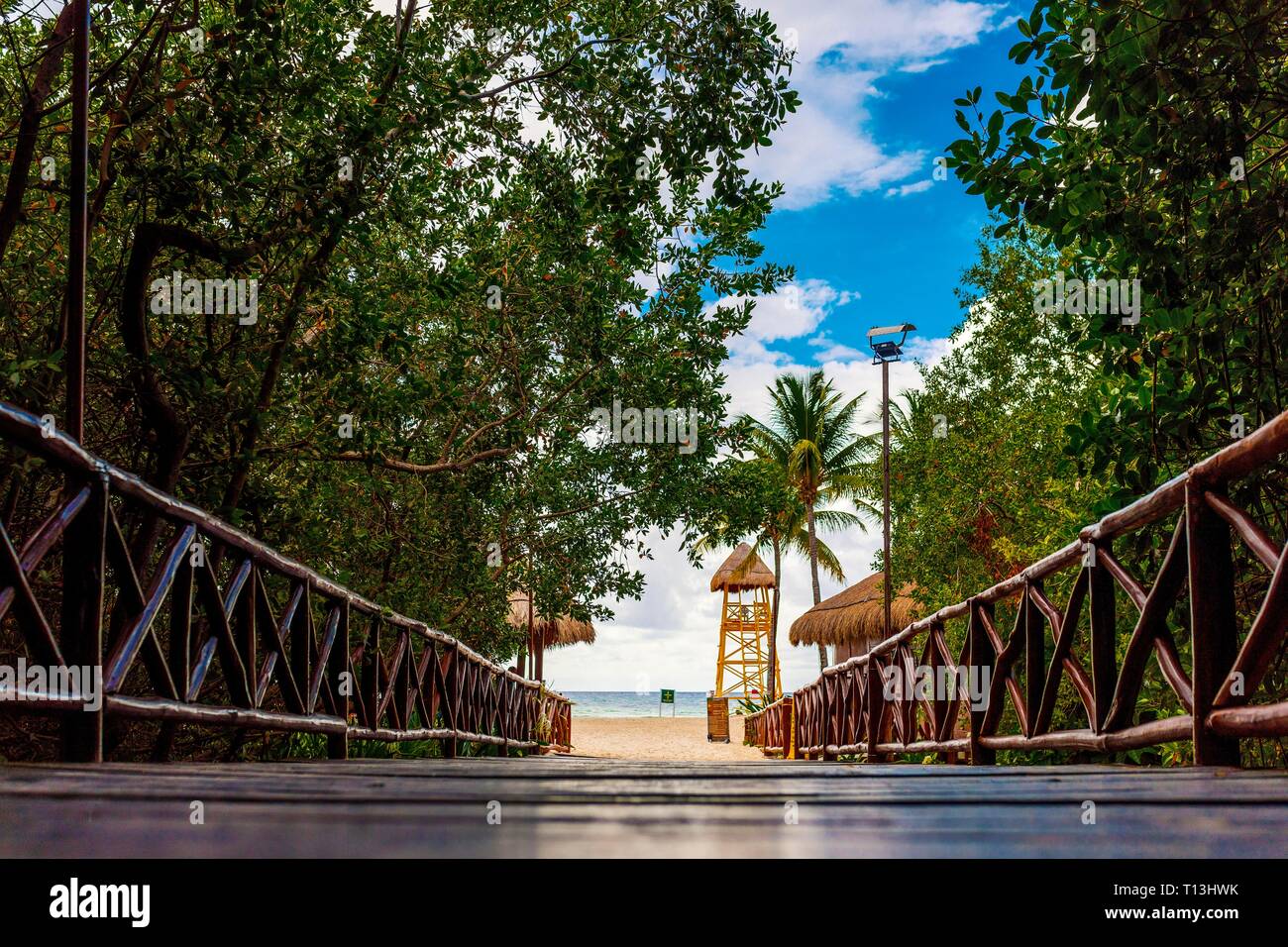 Pont en bois rustique marche à l'ombre et la silhouette des arbres et de la jungle Caribbean beach resort de luxe vers le bas sur la Riviera Maya dans les Caraïbes. Banque D'Images