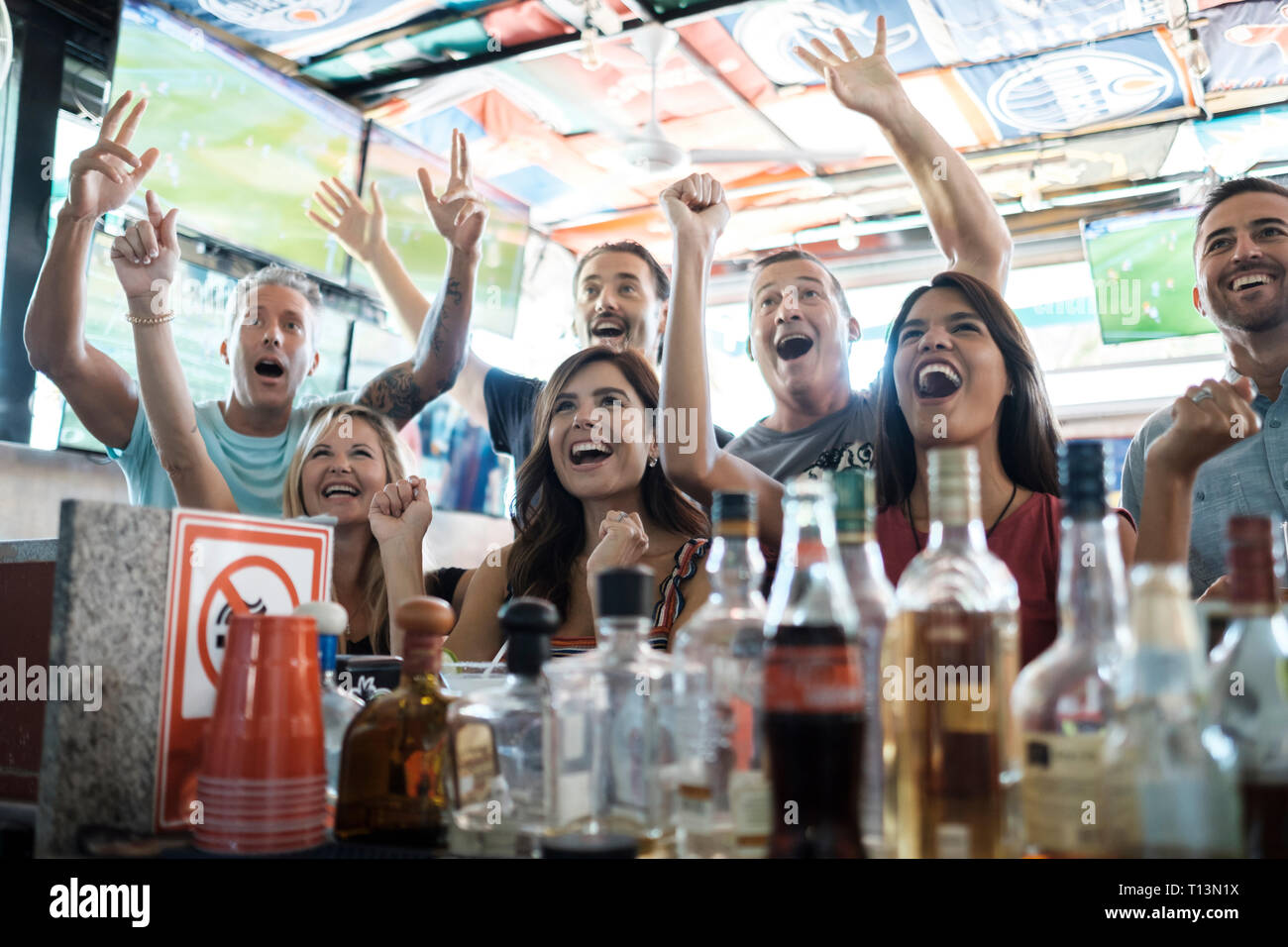 Acclamations des fans excités dans un bar sportif Banque D'Images