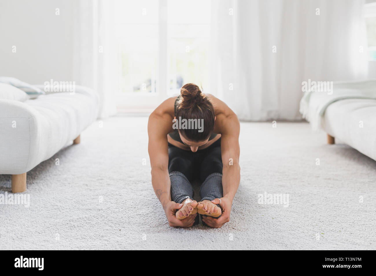 Femme assise sur le plancher la pratique du yoga Banque D'Images