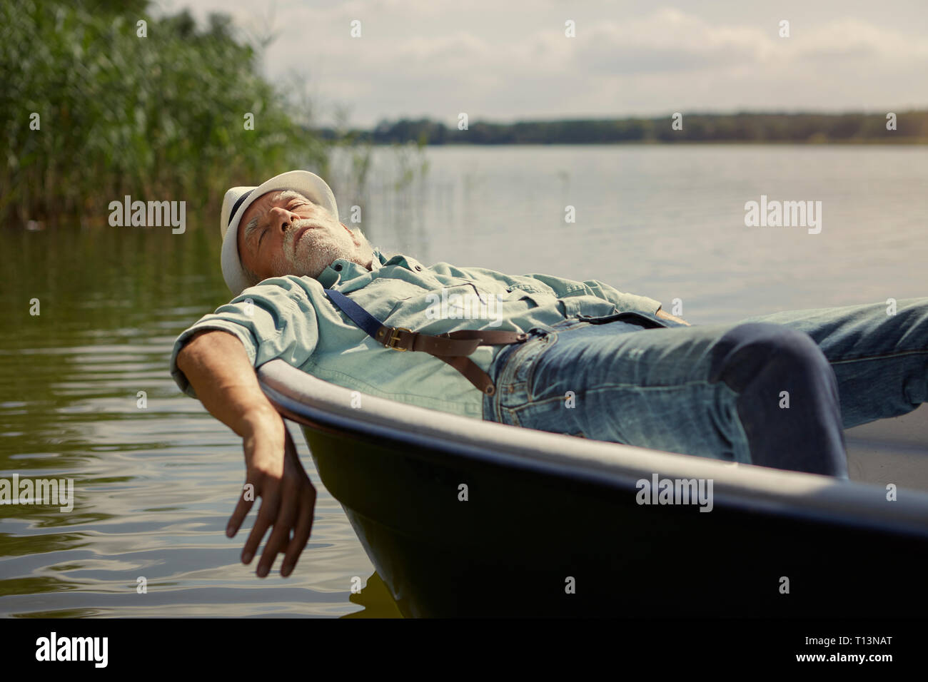 Senior woman relaxing in barque sur un lac Banque D'Images