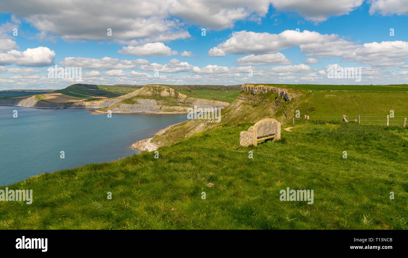 Banc en pierre de la South West Coast Path avec une vue sur la côte jurassique et Emmett's Hill, près de Worth Matravers, Jurassic Coast, Dorset, UK Banque D'Images