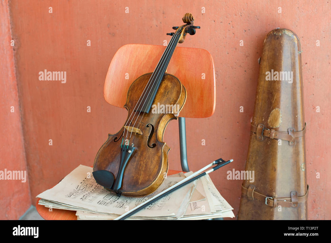 Violon, arc et des feuilles de musique sur chaise en bois avec étui à violon dans l'arrière-plan Banque D'Images