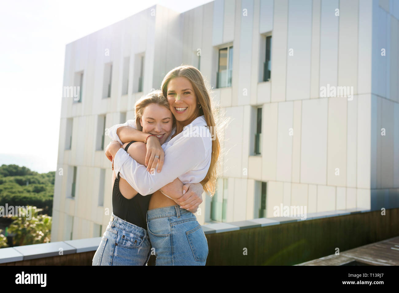 Copines sur une terrasse sur le toit, faire place au bord de la piscine Banque D'Images