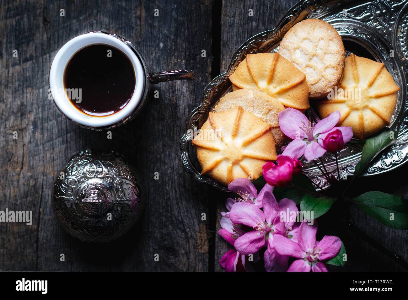 Café savoureux dans un bain turc traditionnel et tasse beurre biscuits et un petit bouquet de fleurs roses sur une table en bois - télévision jeter fond alimentaire Banque D'Images