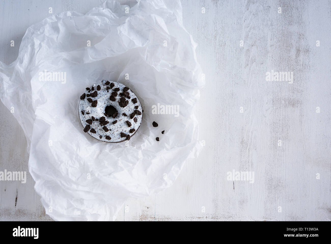 Donut avec glaçage blanc et de chocolat noir sur du papier de soie blanc Banque D'Images
