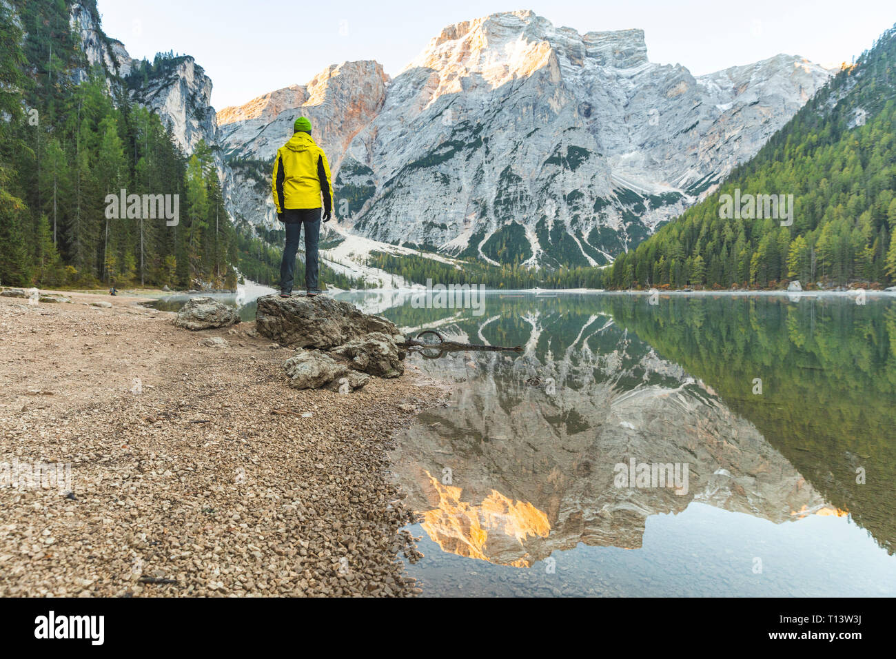 L'Italie, lac de Braies, l'homme au bord de lac avec des montagnes et forêt en arrière-plan Banque D'Images