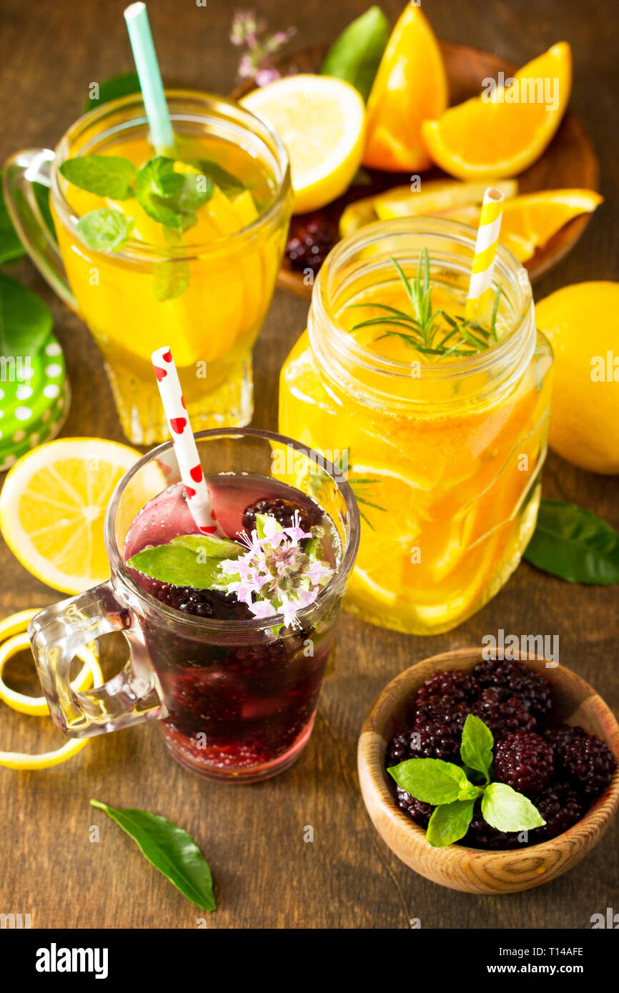 D'été rafraîchissante limonade aux petits fruits, thé à la Menthe et citron limonade orange avec Rosemary sur table en bois dans un style rustique. Banque D'Images