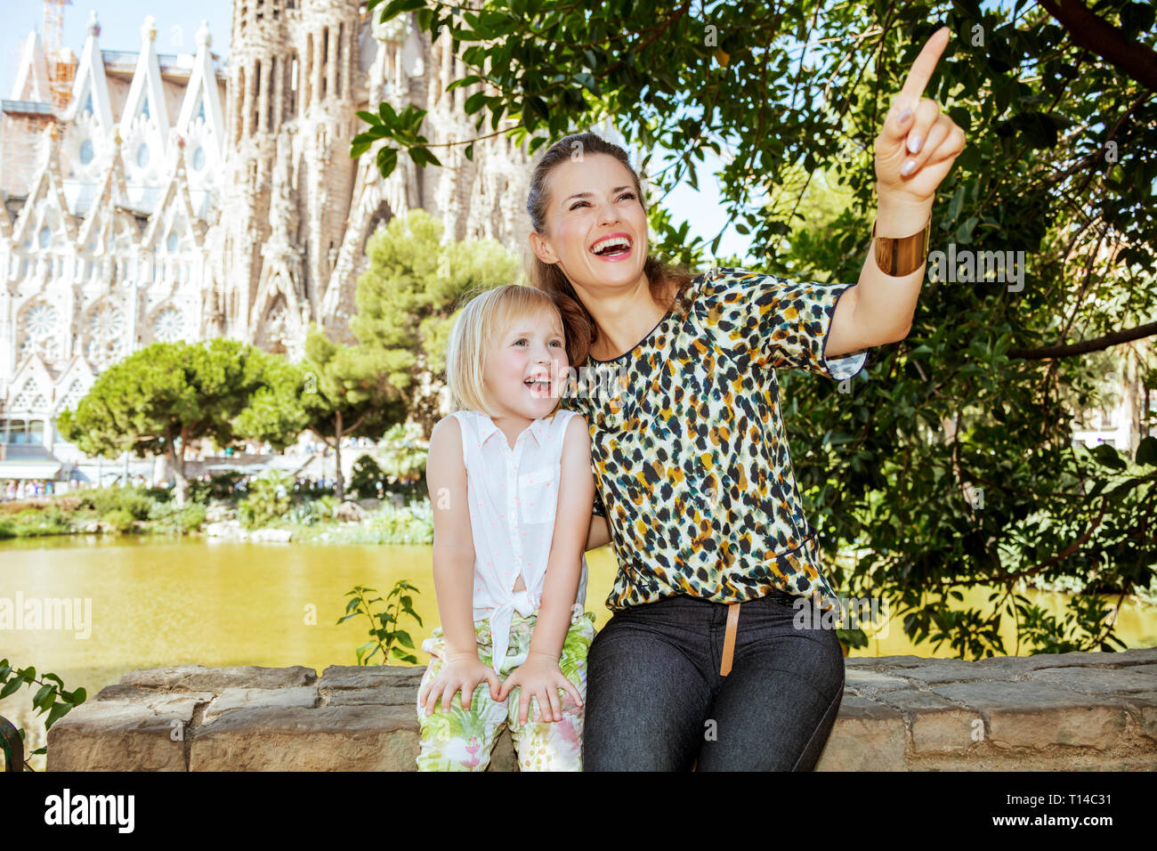 - Barcelone, 06 août 2015 : Mère et fille élégante du doigt quelque chose contre la Sagrada Familia à Barcelone, Espagne. Banque D'Images
