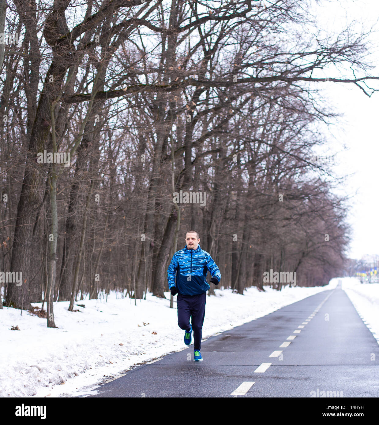 L'homme en bleu tournant Runner run d'usure en hiver Banque D'Images