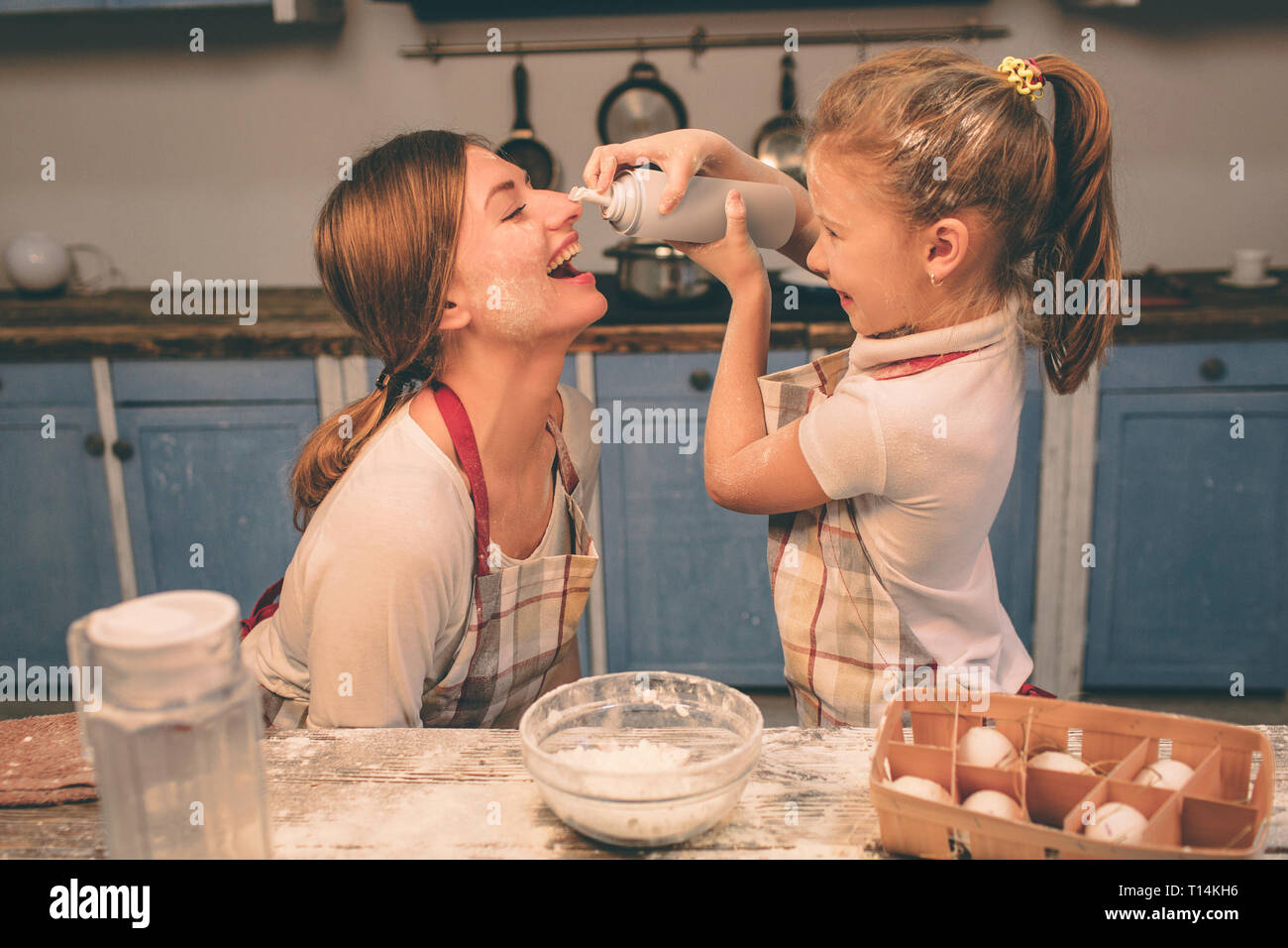 Shaked crème fouettée. Heureux famille aimante préparent ensemble la boulangerie. Mère et enfant fille fille sont la cuisson des cookies et d'avoir du plaisir dans l'kitc Banque D'Images