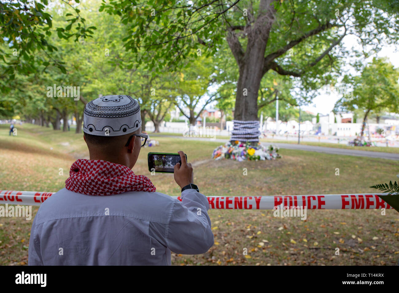 Christchurch, Canterbury, Nouvelle-Zélande, le 22 mars 2019 : un musulman prend des photos des tributs floraux à gauche en face de l'Masij Al Noor en sympathie Banque D'Images