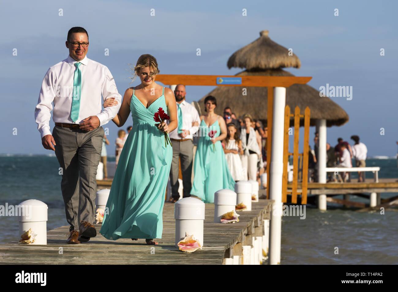 Couple marié juste marcher sur la pêche Dock Pier après la cérémonie de mariage de plage tropicale à Caye Caulker Belize Banque D'Images