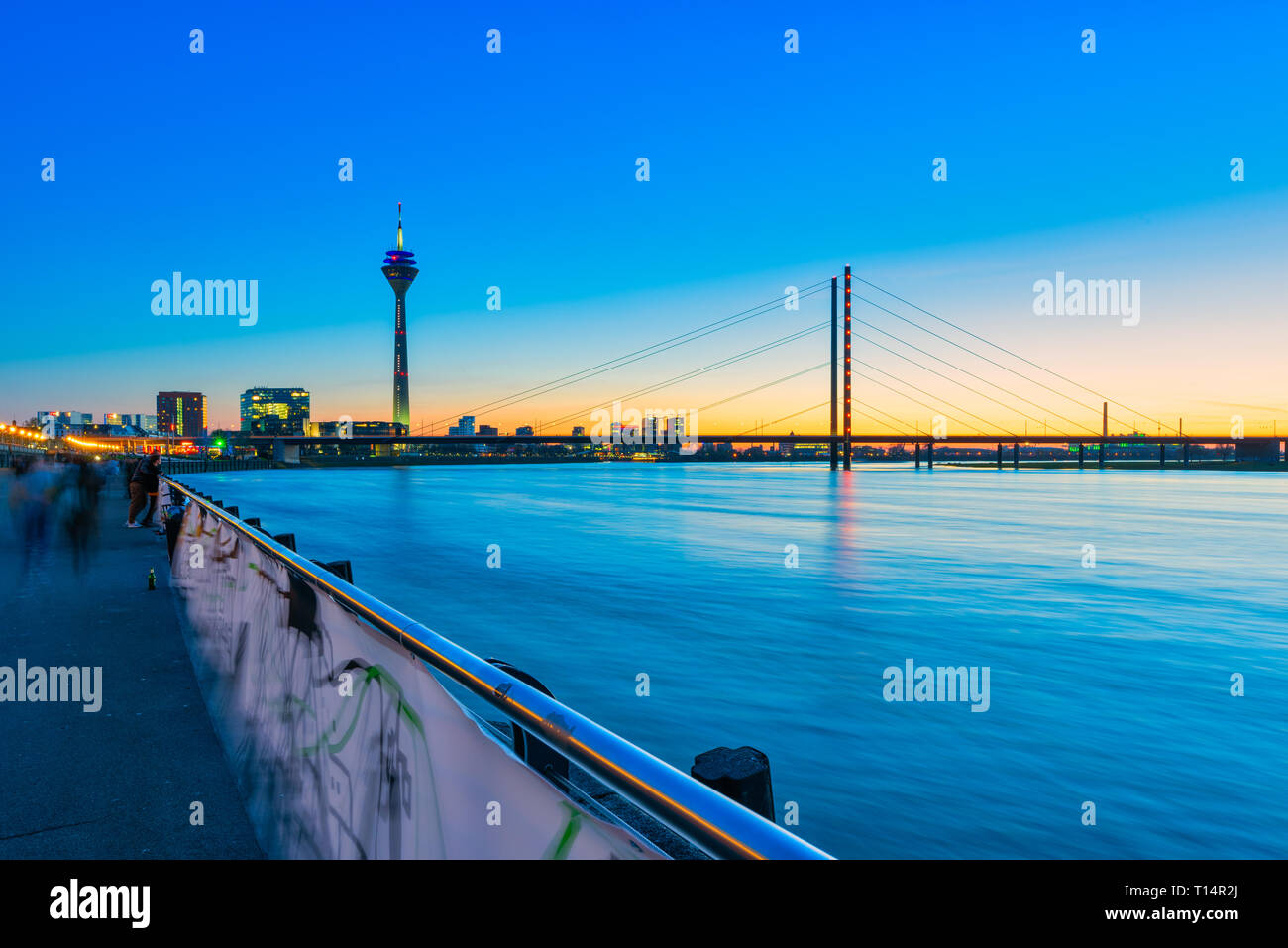 Düsseldorf, Allemagne - 22 mars 2019 pedestrans Inidentified : promenade le long de la promenade du Rhin dans l'glooming coucher du soleil Banque D'Images
