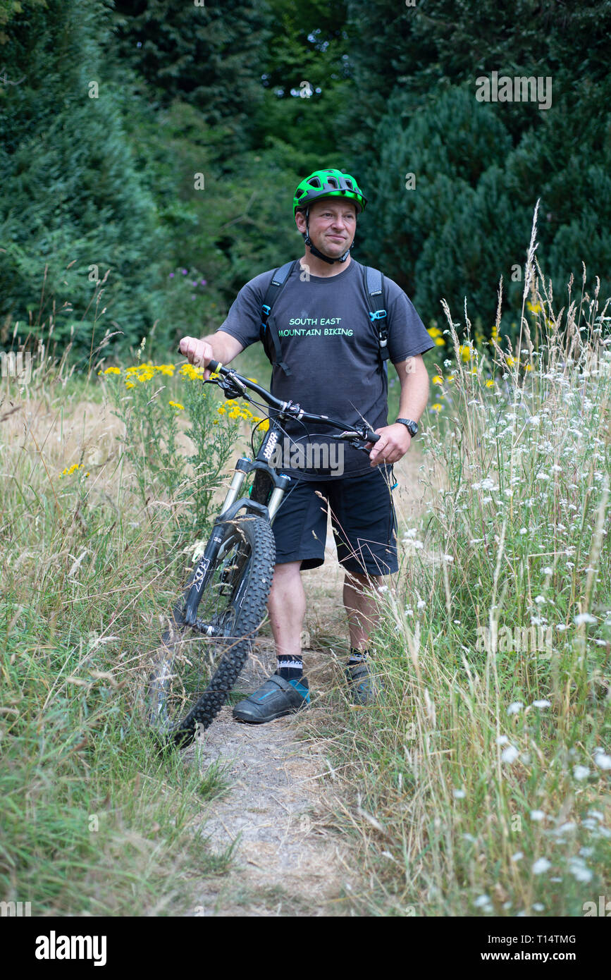 Un homme sur un vélo de montagne de suspension sur les sentiers en Stanmer park, Brighton Banque D'Images