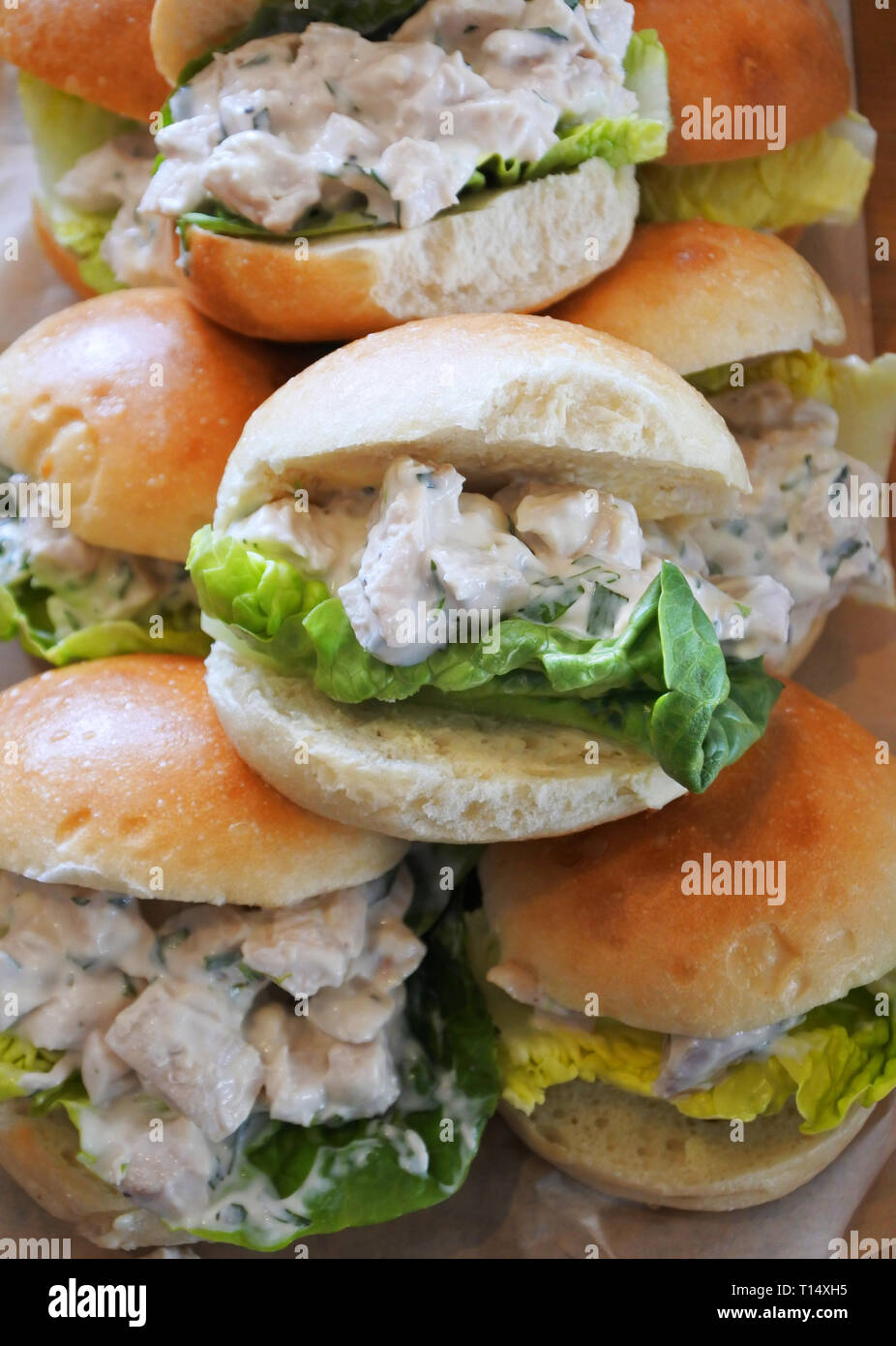 Close-up d'un groupe de poulet et de la mayonnaise à la main rempli de petits pains - John Gollop Banque D'Images
