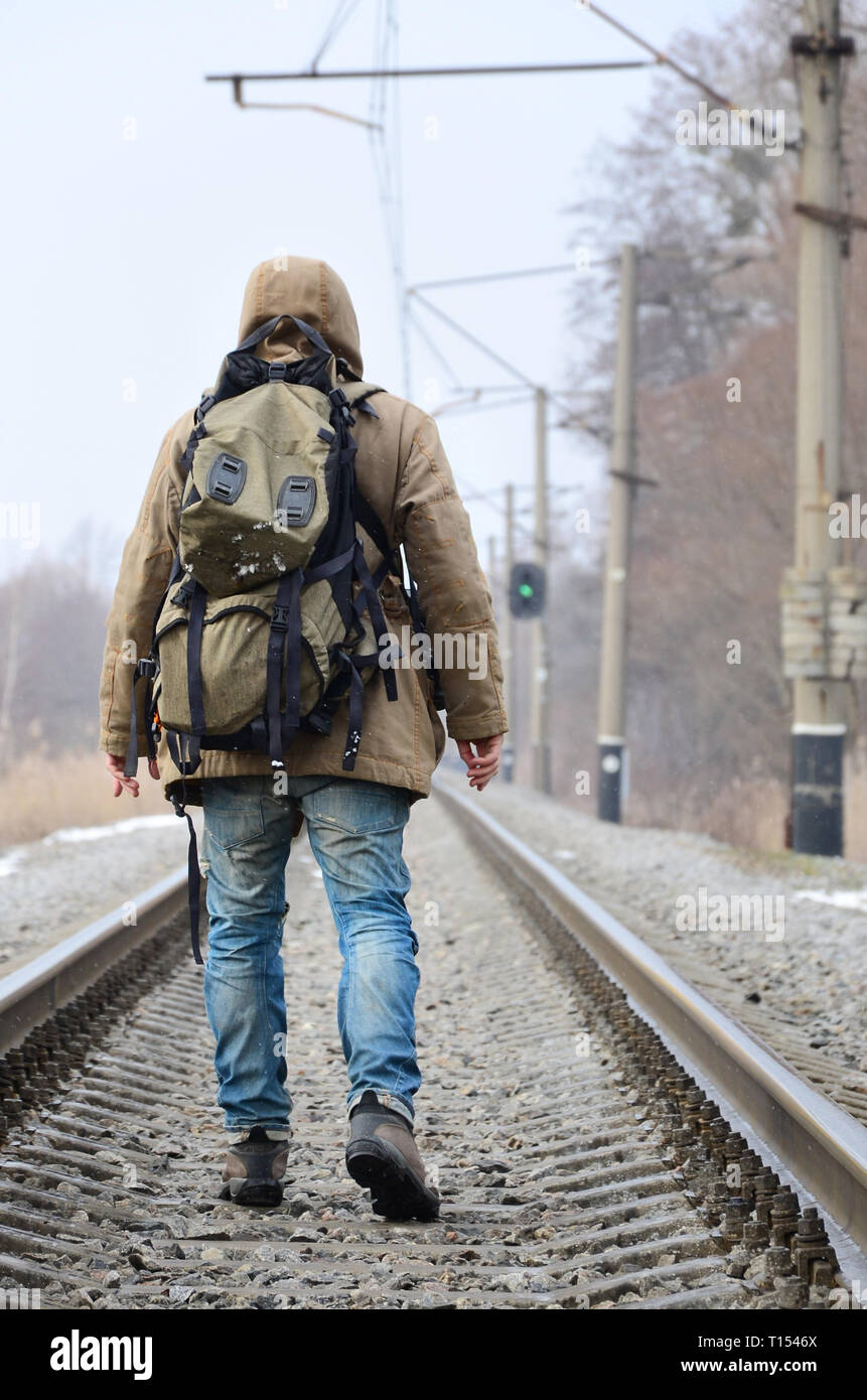 Un homme avec un grand sac dos va de l avant sur la voie de