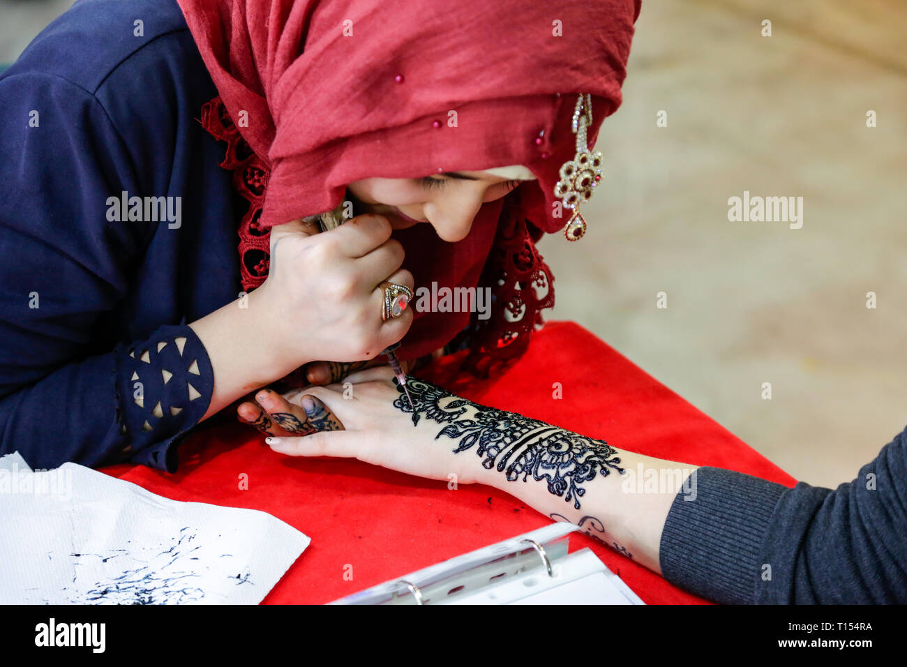 Fille asiatique peinture sur les mains avec le henné, en costume oriental typique, de l'intérieur Banque D'Images