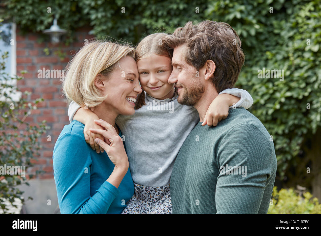 Portrait de famille heureuse dans le jardin de leur maison Banque D'Images