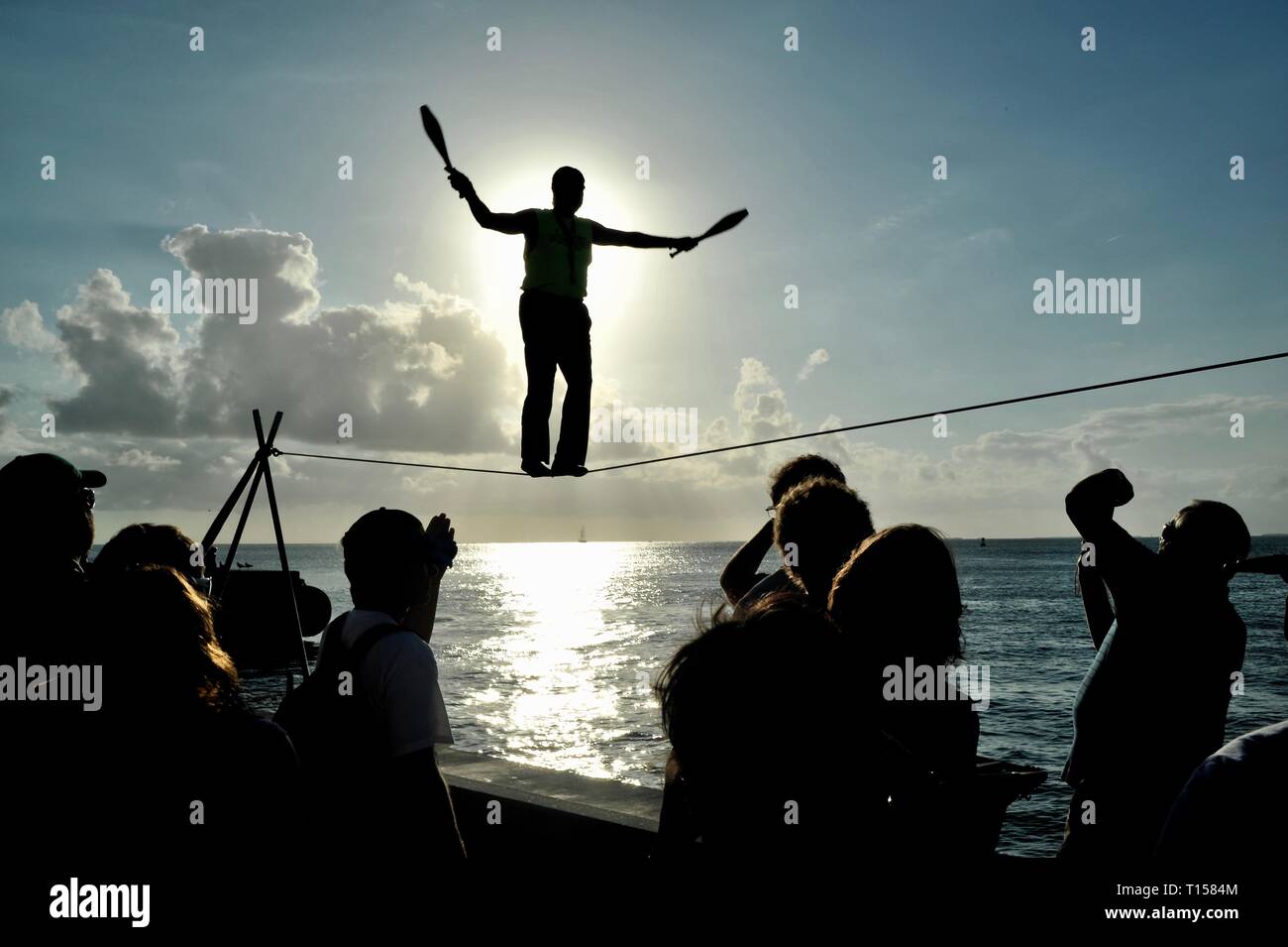 Artiste de la rue de sexe masculin en équilibre sur corde raide tout en jonglant, divertir les foules, Mallory Square Sunset Celebration, Key West, Florida Keys, Floride, USA Banque D'Images