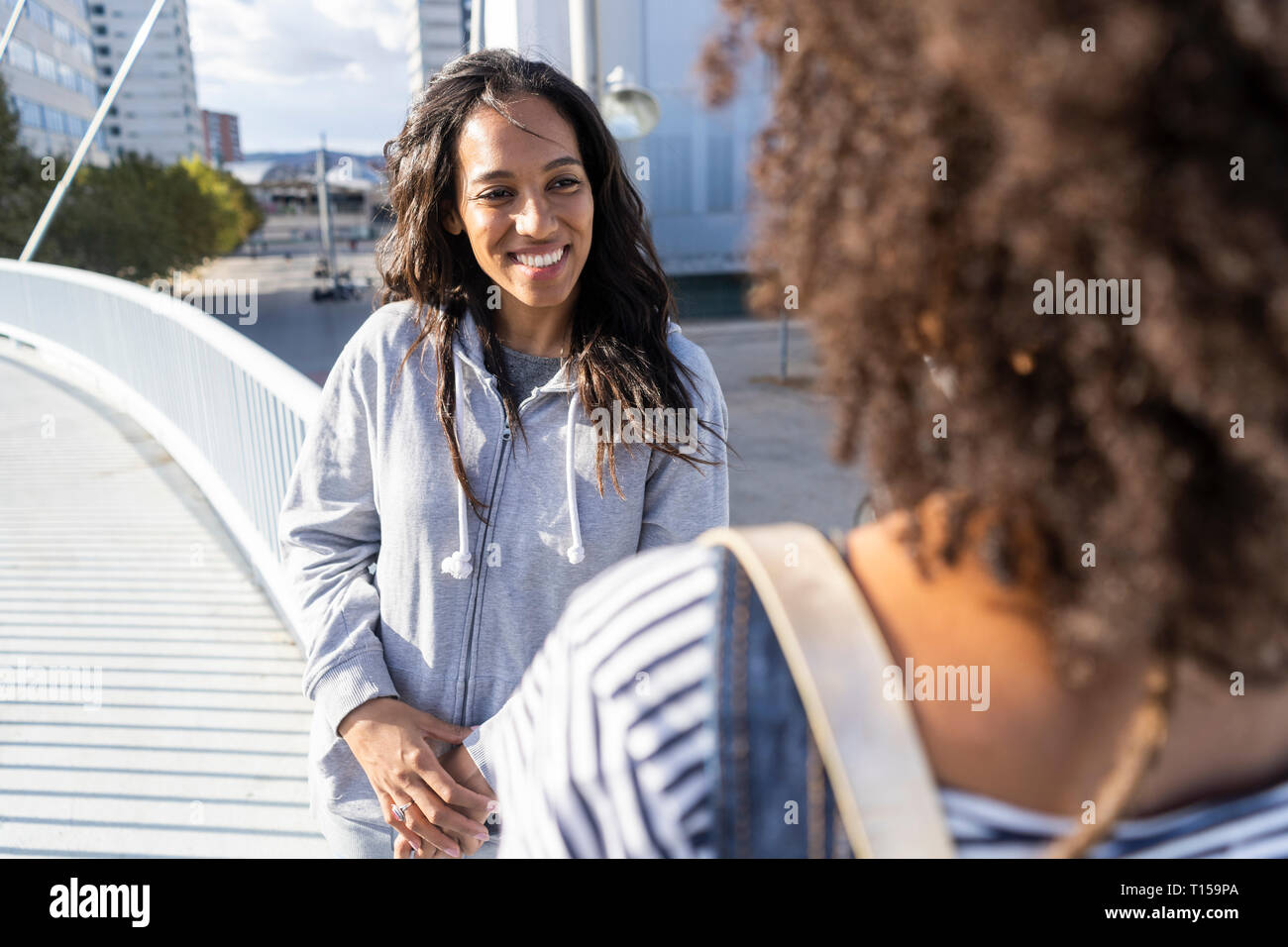 Girl friends meeting sur un pont, s'amusant Banque D'Images