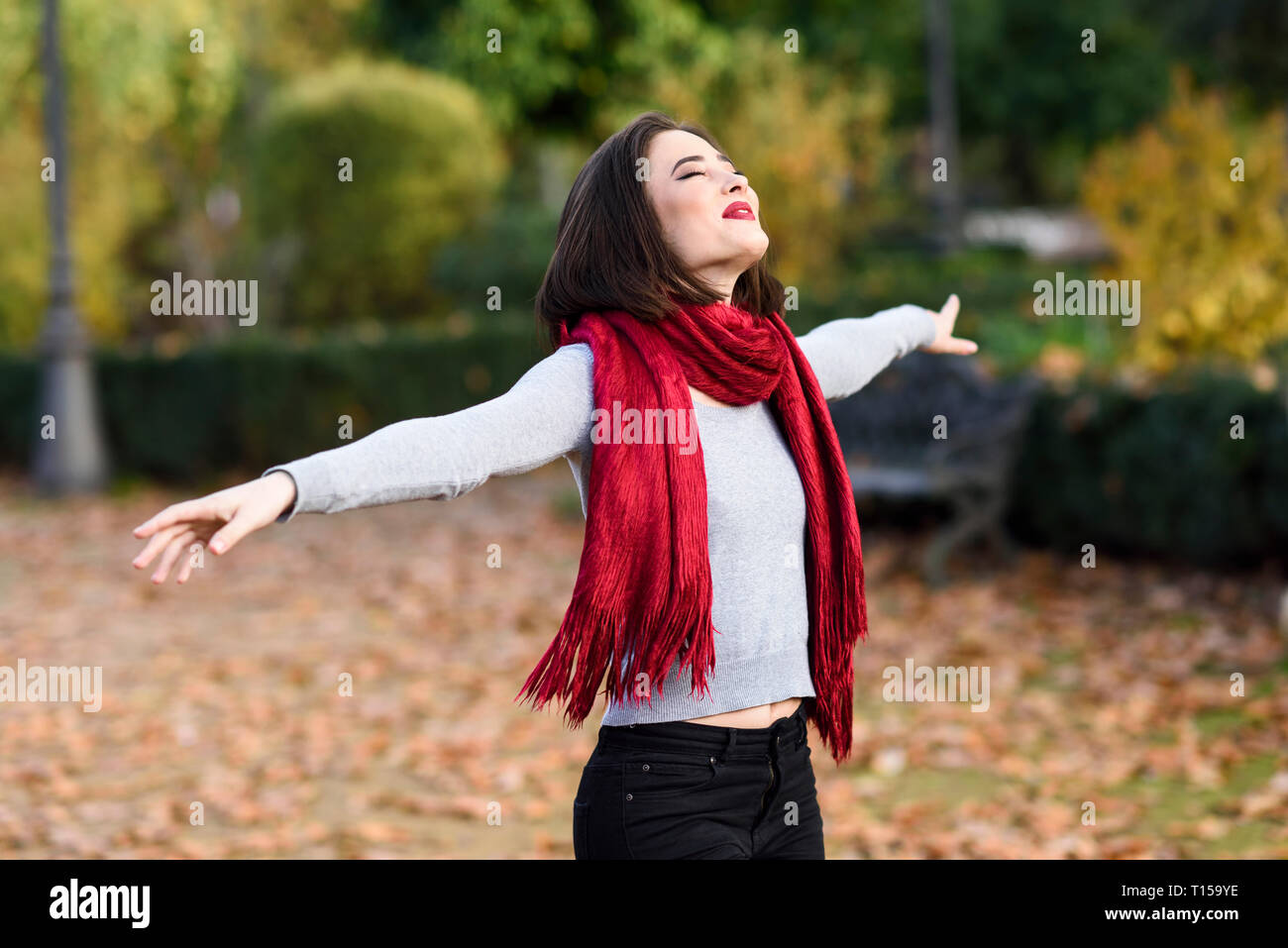 Happy young woman wearing scarf rouge en automne Banque D'Images