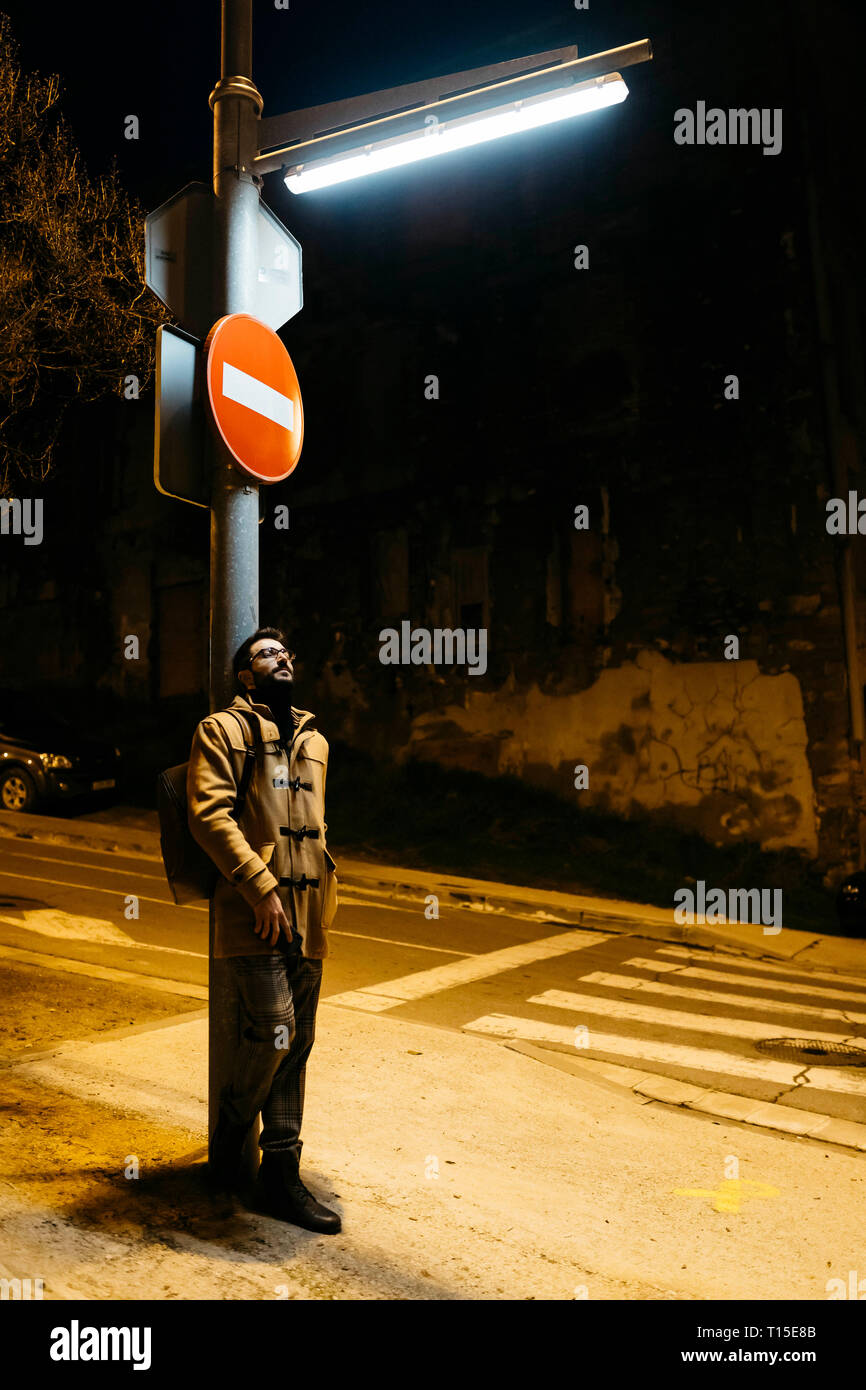 L'Espagne, Igualada, l'homme debout sous une lampe de rue la nuit Banque D'Images