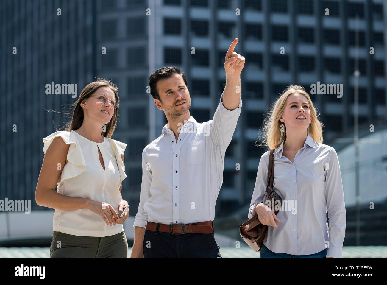 Homme d'affaires avec des collègues dans la ville pointant son doigt Banque D'Images