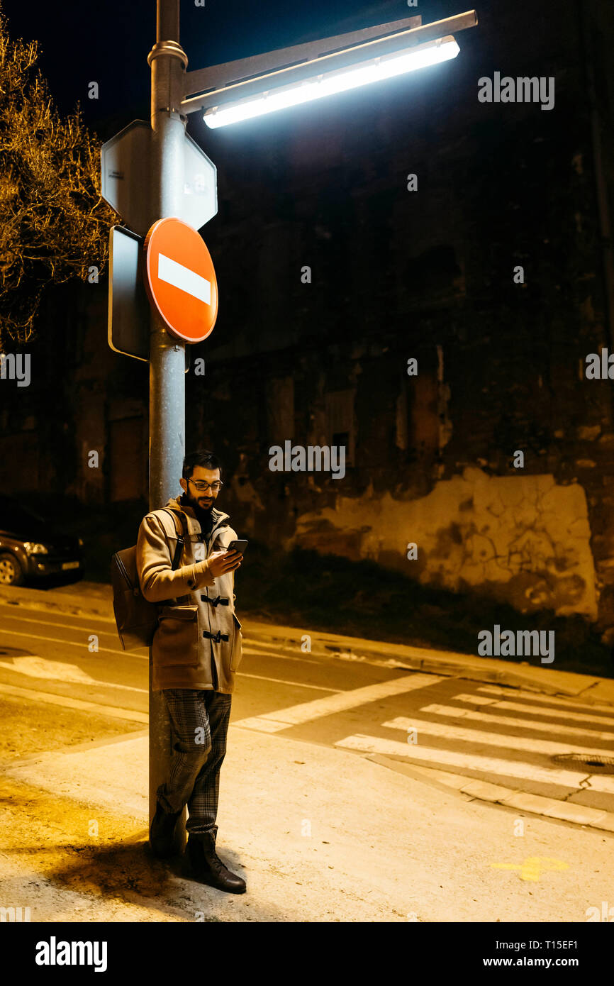 L'Espagne, Igualada, l'homme debout sous un réverbère, la nuit, un téléphone cellulaire Banque D'Images