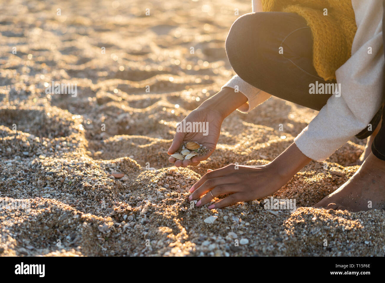 Femme la collecte des coquillages sur la plage Banque D'Images