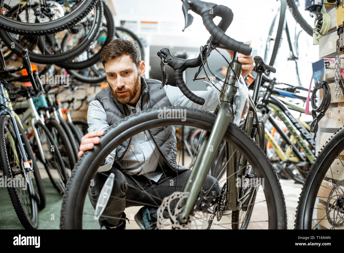 Le choix de l'homme nouveau vélo pour acheter l'article dans le magasin  avec beaucoup de bicyclettes et d'équipements de sport à l'intérieur Photo  Stock - Alamy
