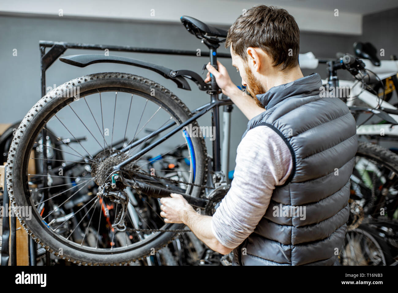 Servant un réparateur beau vélo, régler certains dysfonctionnements, le sélecteur de vitesse à l'atelier Banque D'Images