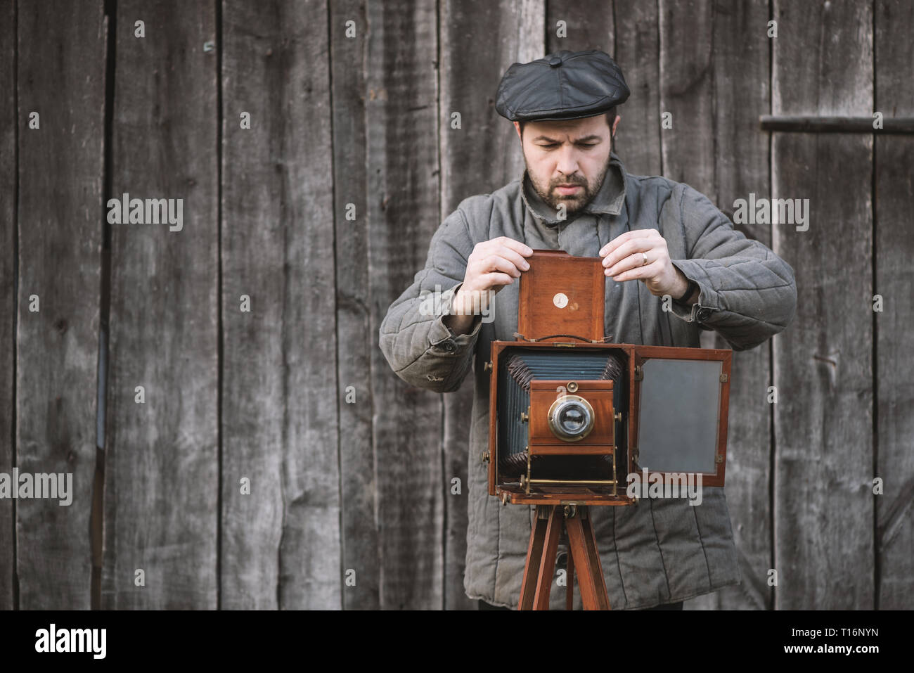 Photographe se prépare pour le tournage et l'insère dans le support film grand format rétro. Concept - Photographie des années 1930 aux années 1950. Banque D'Images