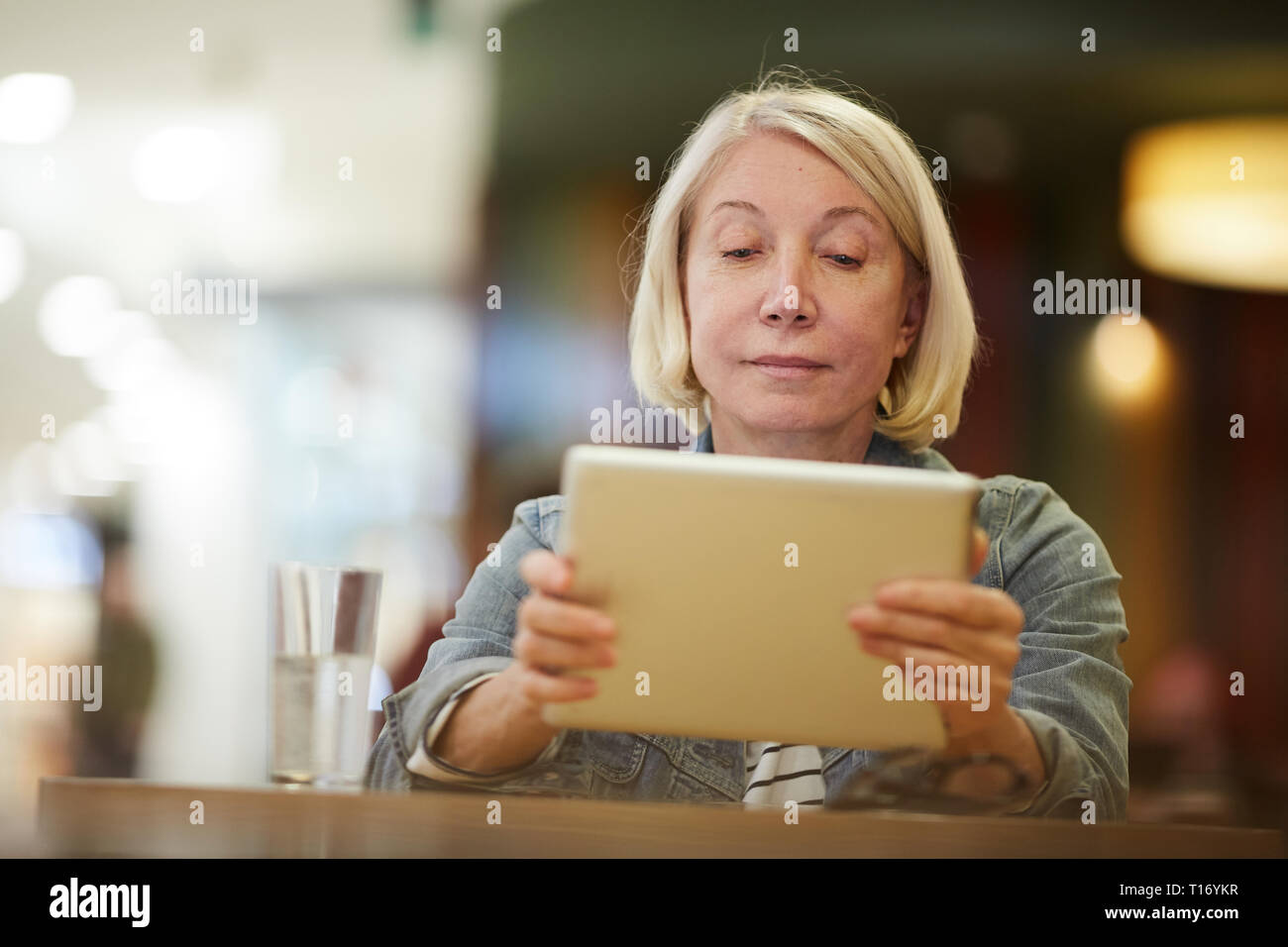 Pensive dame regardant la vidéo sur tablette Banque D'Images